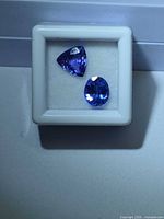 Two loose tanzanite gemstones in white display box