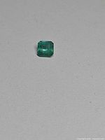 Loose octagon-cut emerald on neutral background