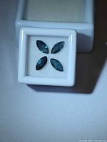 Four marquise blue sapphires in a gem box, overhead view
