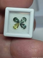 Four pear-cut multicolour sapphires in display case