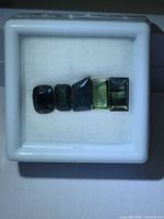 five faceted sapphires in gem box, top view