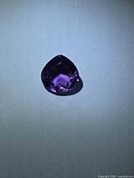 Pear-cut amethyst on neutral background showing face-up colour