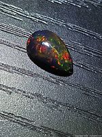 Pear cabochon Ethiopian black opal showing multicolor fire