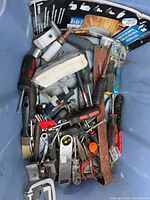 Top view of bin showing screwdrivers, file, putty knife, clamp, sharpening stone, bits