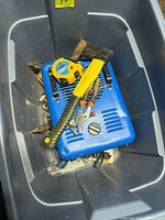 View of plastic tote containing Mastercraft heater, tape measure, hammer, pliers and other tools
