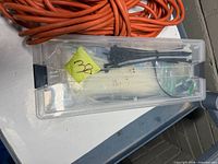Orange extension cord, clear box with zip ties
