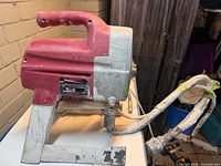 Left side view of Titan XT250 sprayer showing handle, stand and hose connection