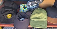Overall lot showing six of the hats including sunflower bucket, Reebok, Vans, RBX, LRG and lemon print cap