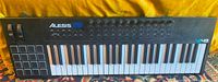 Front view of Alesis VI49 keyboard showing keys, pads, knobs, wheels, and logos