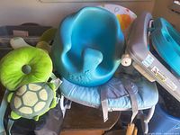 Bumbo seat, turtle headrest, bouncer seat visible