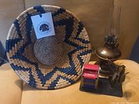 Overview: basket, brass lamp, tin stamp dispenser with scale
