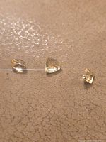 Three pale yellow faceted stones lined up
