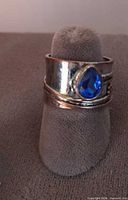 Front view of mixed metal ring showing pear-shaped sapphire