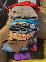 Stack of folded apparel showing variety of fabrics, colours and garment types