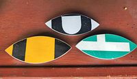 Front view of three eye-shaped street sign pins showing colors and graphics