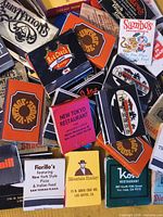 Pile of multicolour vintage restaurant matchbooks showing titles like Ray Coach, Vintage House, New Tokyo Restaurant, Fiorillo's