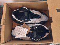 Pair of Yeezy Boost 700 MNVN sneakers inside box with tags attached