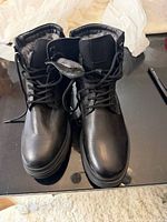 Front view of both black leather boots, laced, showing exterior condition