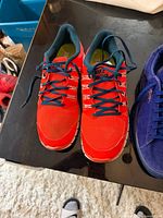Red Nike mesh running sneakers, teal laces, size label not visible
