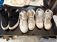 Three pairs of sneakers lined up side by side on table