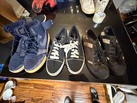 Overview of three pairs of men’s sneakers on table