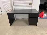 Front view of dark wood desk showing overall design and pedestal