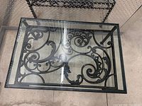 Top view of table showing glass insert and scrollwork metal support
