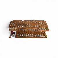 full group of souvenir spoons on display rack
