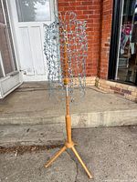 Full view of adjustable wire dress form on wooden tripod stand