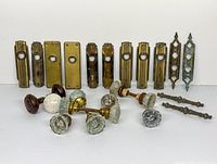 Front view showing glass knob sets, single knobs, brass backplates and drawer pulls