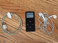 Front view of black iPod Nano with 30-pin cable left and earbuds right