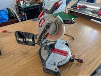 Overall view of Craftsman compound mitre saw with dust bag attached on workbench