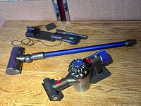 Entire Dyson V8 stick vacuum with floor head, wand, docking station, combination and crevice tools