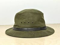 Left side view of olive Filson Tin Cloth Packer Hat showing black band and grommets