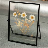 Full view of pressed flower artwork standing on built-in metal stand