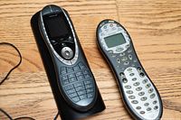 Harmony 880 remote on charging cradle and Harmony 659 remote side by side
