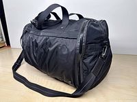 Side view of black Lululemon Urban Warrior duffel showing body fabric and shoulder strap
