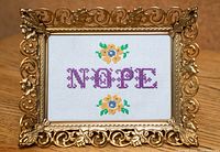 Front view showing cross-stitch design and ornate frame