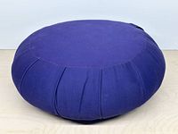 Top and side view of dark blue round meditation cushion showing pleated sides