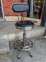 Full view of tall swivel stool showing seat, backrest, frame and footrest