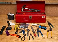 Full view of open red toolbox and spread-out tools on tabletop