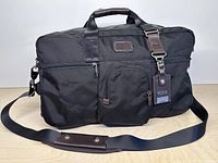 Front view showing overall design, handles, shoulder strap and exterior pockets