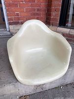 Front view of off-white Eames fiberglass armchair shell