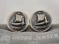 Front view of both cufflinks on pouch showing Viking ship motif