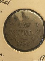 Reverse of 1926 Canada one cent coin showing maple leaves and date within flip