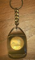 Front view of resin pendant showing obverse side of 1996 Canadian dollar coin