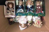Box containing four boxed Century dolls, one boxed Christine doll, and three loose porcelain dolls