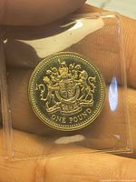 Reverse of 1983 proof pound coin showing Royal Arms, in plastic sleeve