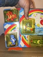 Four Care Bear figures sealed on single card showing characters and product codes