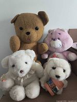All four plush bears grouped: brown, pink, white with collar, WWF polar bear